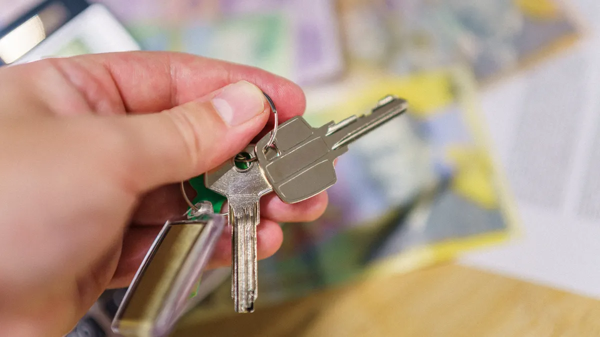 Hand holding several house keys