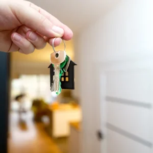 Hand holding house keys in a doorway