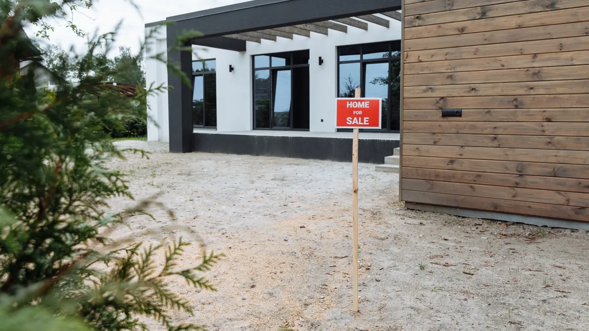 Modern home with a for sale sign outside