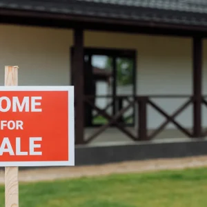 House with a for sale sign in front